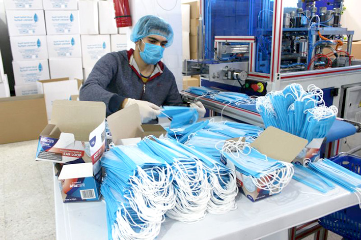 Un trabajador con una mascarilla facial y guantes en una fábrica de mascarillas, como parte de las medidas de precaución contra el coronavirus, en Misrata