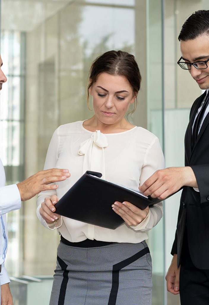 smiling-managers-reading-work-instructions-1-704x1024